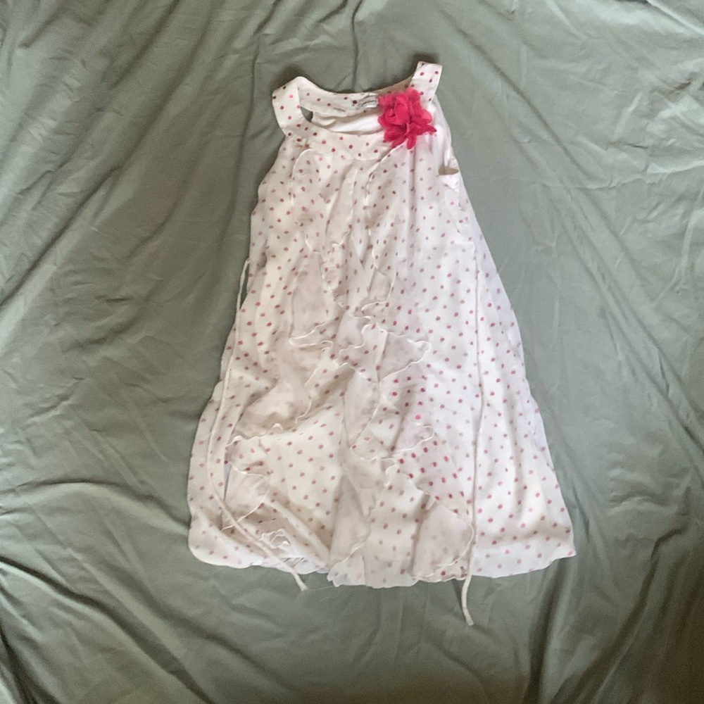 White and pink sundress with a pink flower and ruffles.